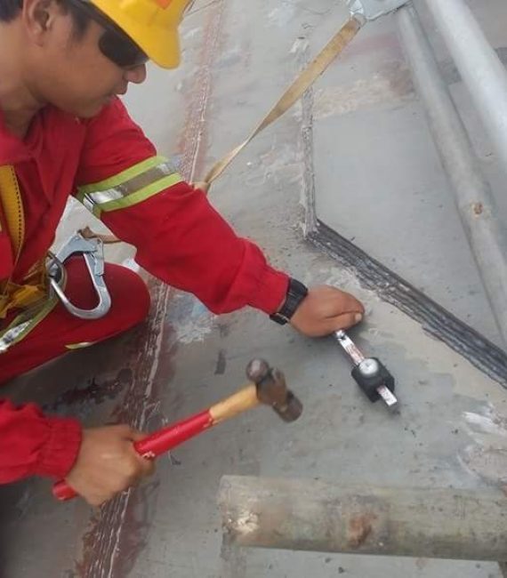 hardness-testing-man-wearing-red-uniform-working